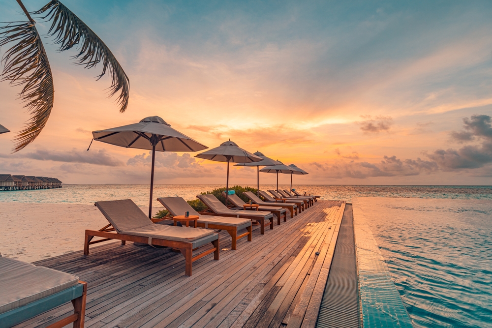 Tropical sunset over outdoor infinity pool in summer