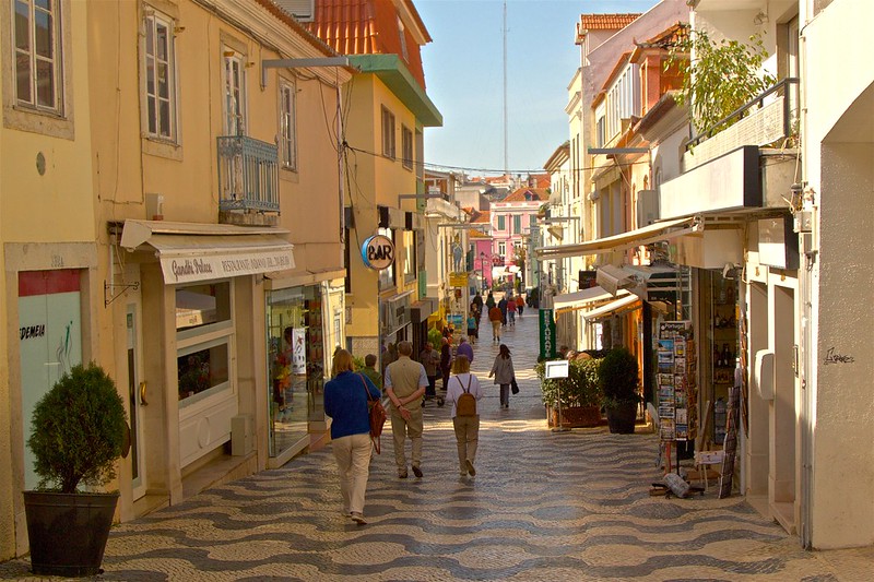 Tourists walking in High Street by the Sea. Cascais Portugal.