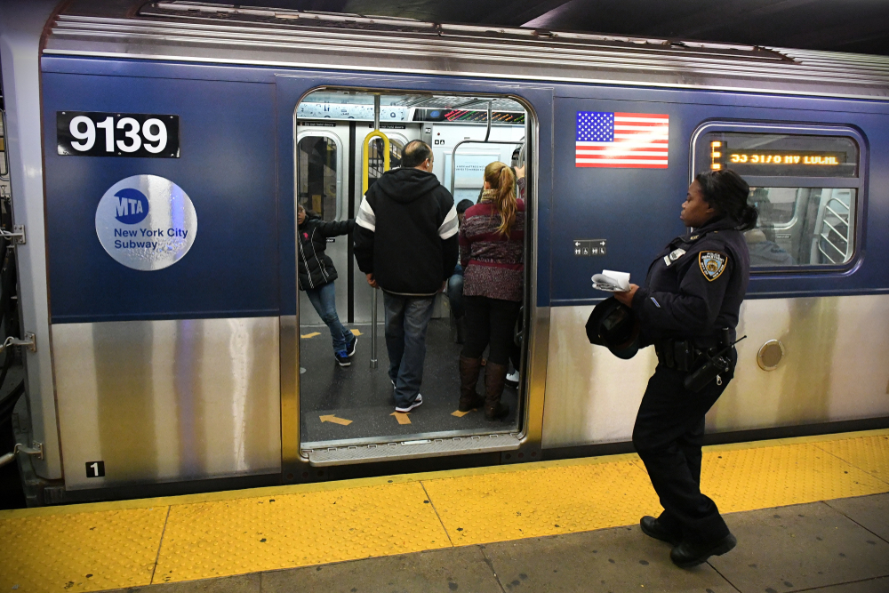 A female police officer boards an E train subway