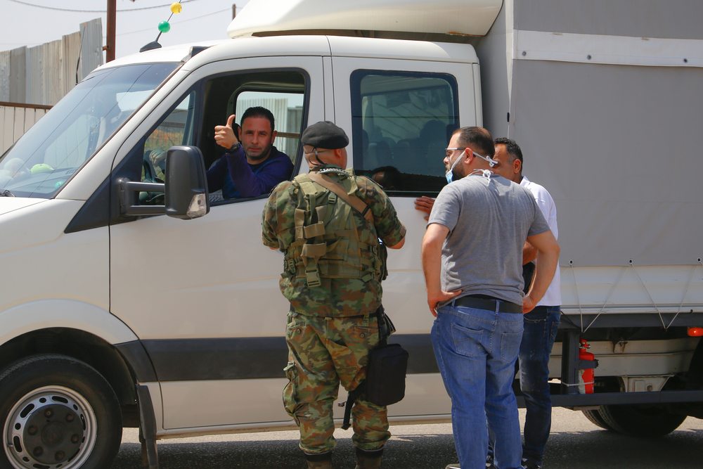 soldier wearing mask stand guard at a roadblock