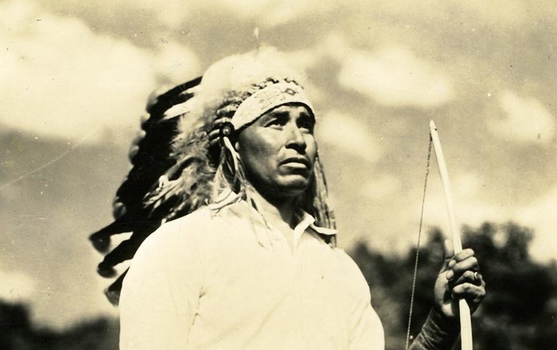 Cherokee man in a headdress, holding a bow