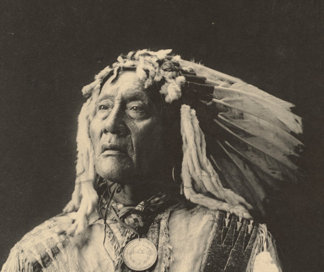 Grayscale Portrait Photo of Native American man in traditional clothing
