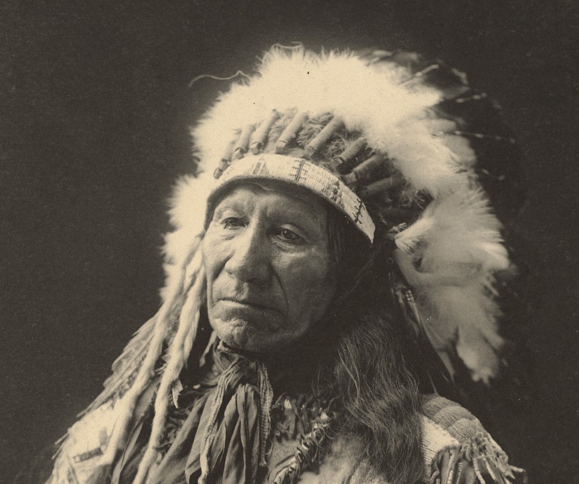 Grayscale Portrait Photo of Native American man in traditional clothing