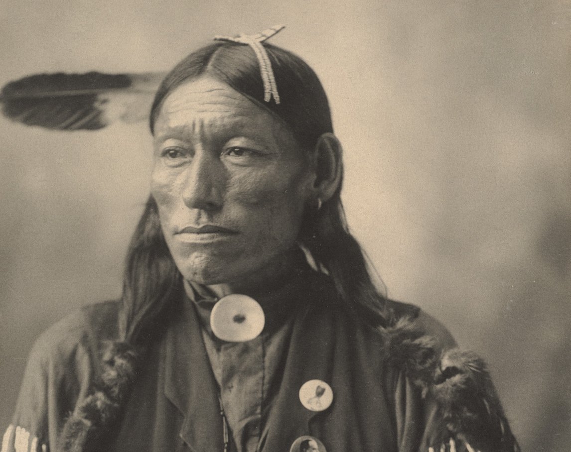 Grayscale Portrait Photo of Native American man in traditional clothing