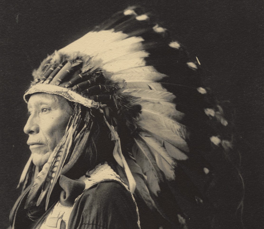 Grayscale Portrait Photo of Native American man in traditional clothing