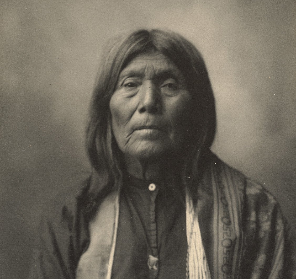 Grayscale Portrait Photo of Native American woman in traditional clothing.