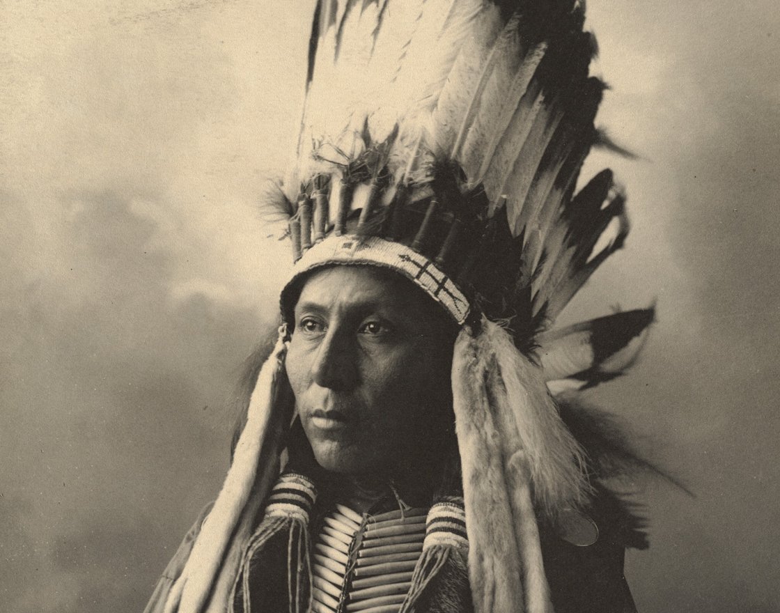 Grayscale Portrait Photo of Native American man in traditional clothing