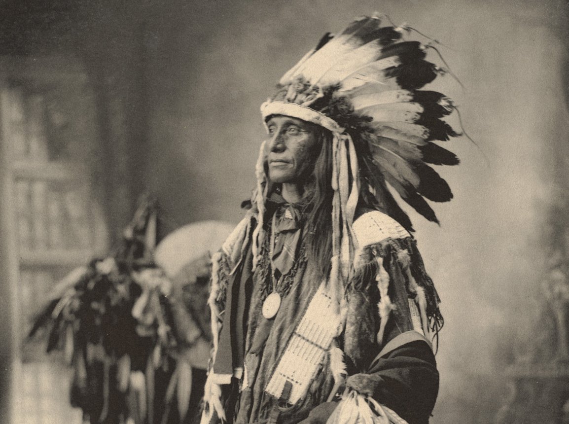 Grayscale Portrait Photo of Native American man in traditional clothing