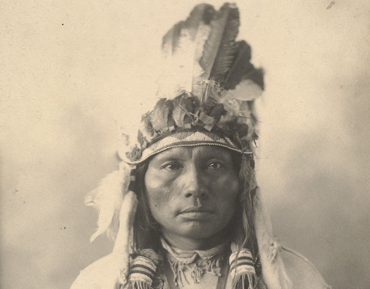 Grayscale Portrait Photo of Native American man in traditional clothing