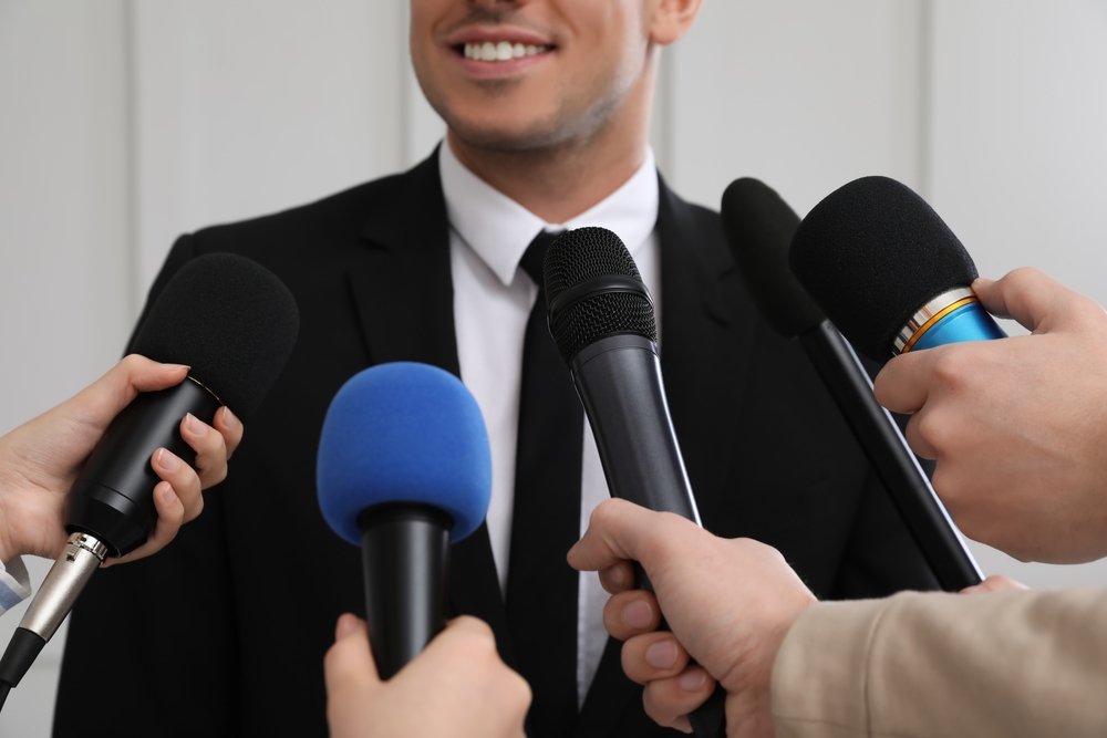Happy business man giving interview to journalists