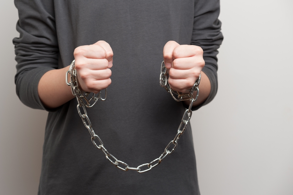 boy's hands are wrapped in a metal chain
