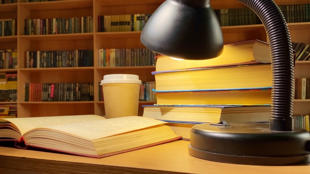 Books, coffee and lamp rotating on desk in library