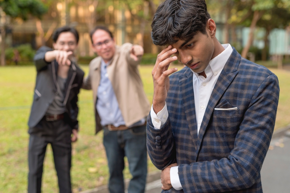 man being mocked by his colleagues