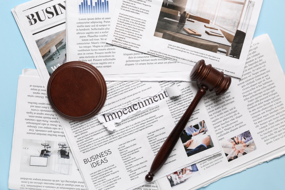 Judge gavel and word IMPEACH on newspapers