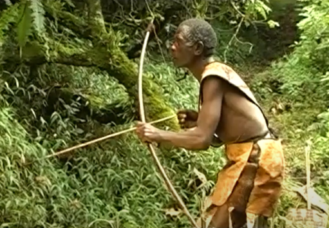 Screenshot of Batwa tribe man hunting in the forest - from The Batwa Legacy (2011)