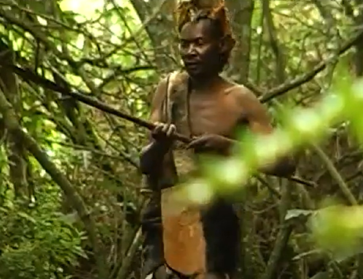 Screenshot of Batwa tribe man hunting in the forest - from The Batwa Legacy (2011)