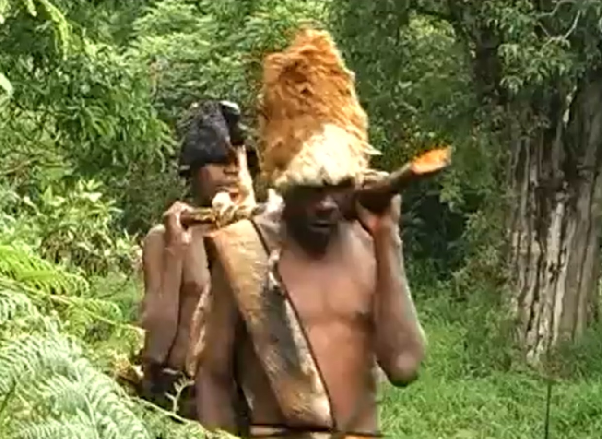 Screenshot of Batwa tribe people holding a meat - from The Batwa Legacy (2011)