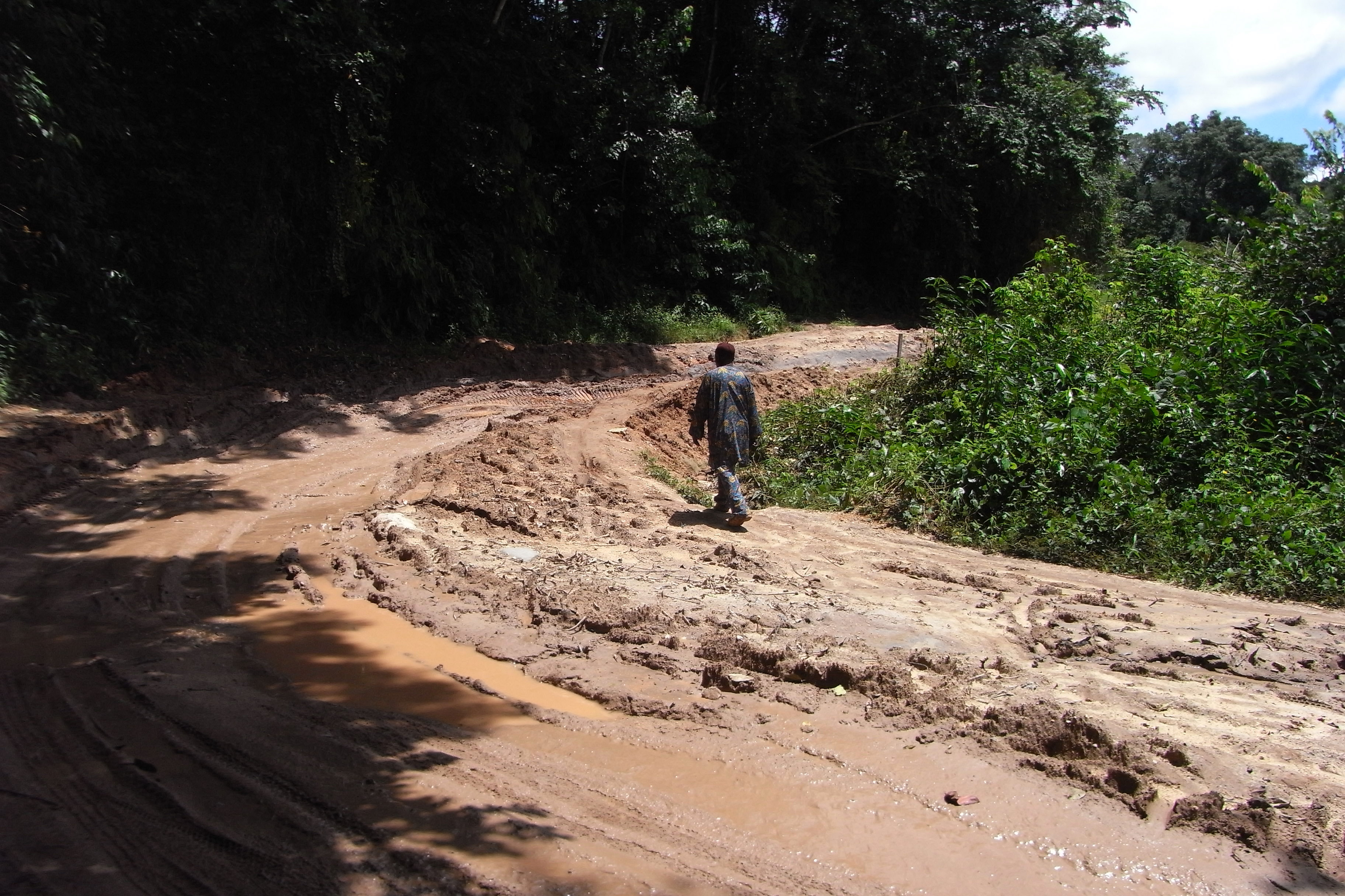 Man walking on muddy road at the countryside.