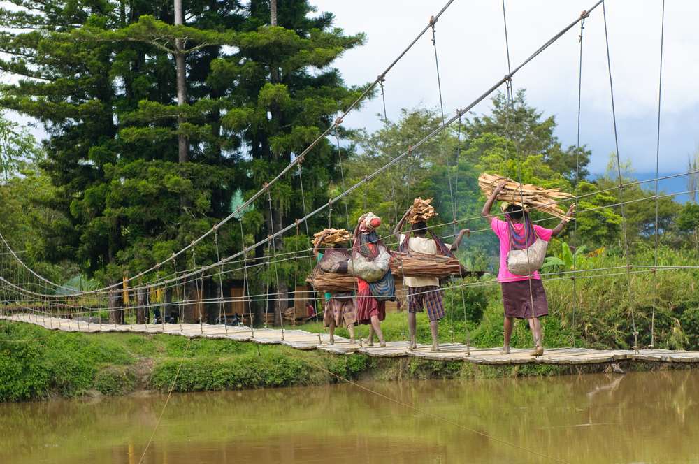 Papuan women crossing bridge