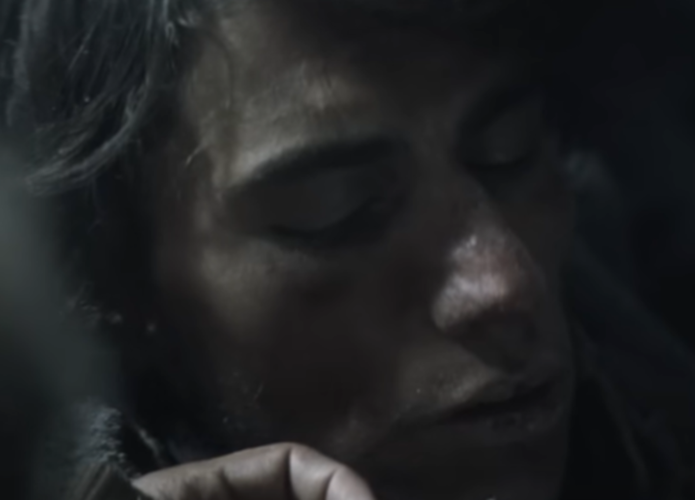 Screenshot of man giving food to other man - from Society of the Snow (2023)