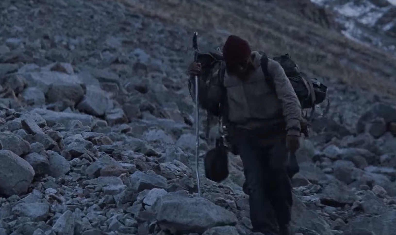 Screenshot of survivor from Flight 571 walking on the mountain - from Society of the Snow (2023)