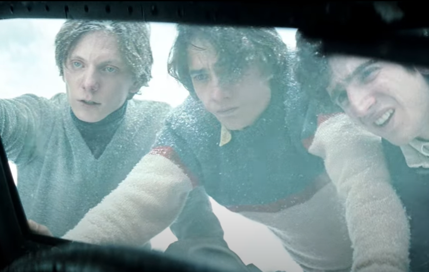 Screenshot of man looking upset outside - from Society of the Snow (2023)