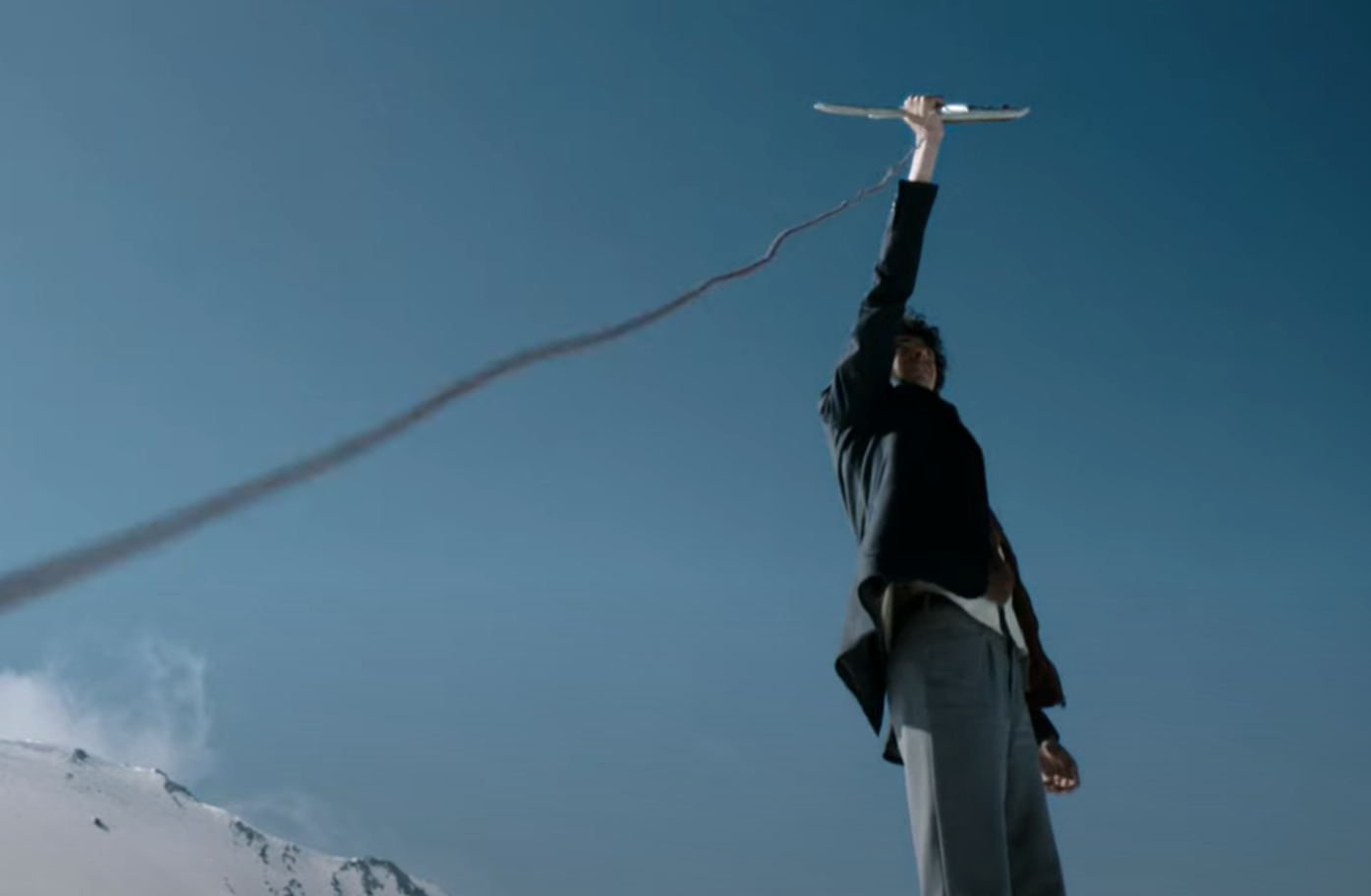 Screenshot of man holding antenna outside - from Society of the Snow (2023)