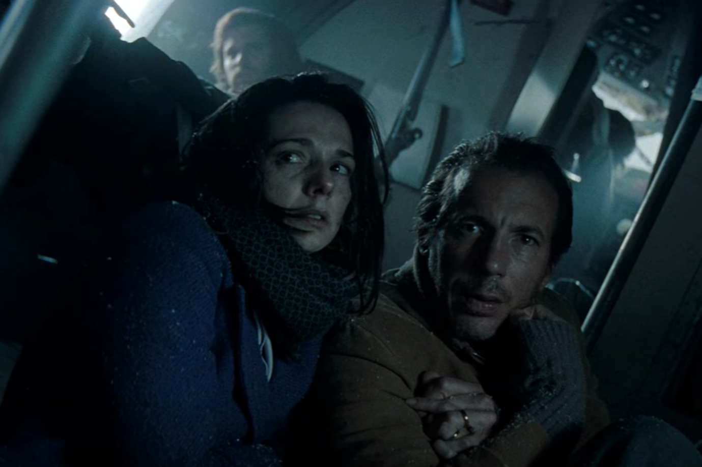 Screenshot of couple looking scared in the plane - from Society of the Snow (2023)