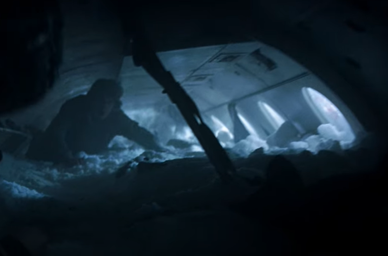 Screenshot of destroyed plane body in the snow with people in side - from Society of the Snow (2023)