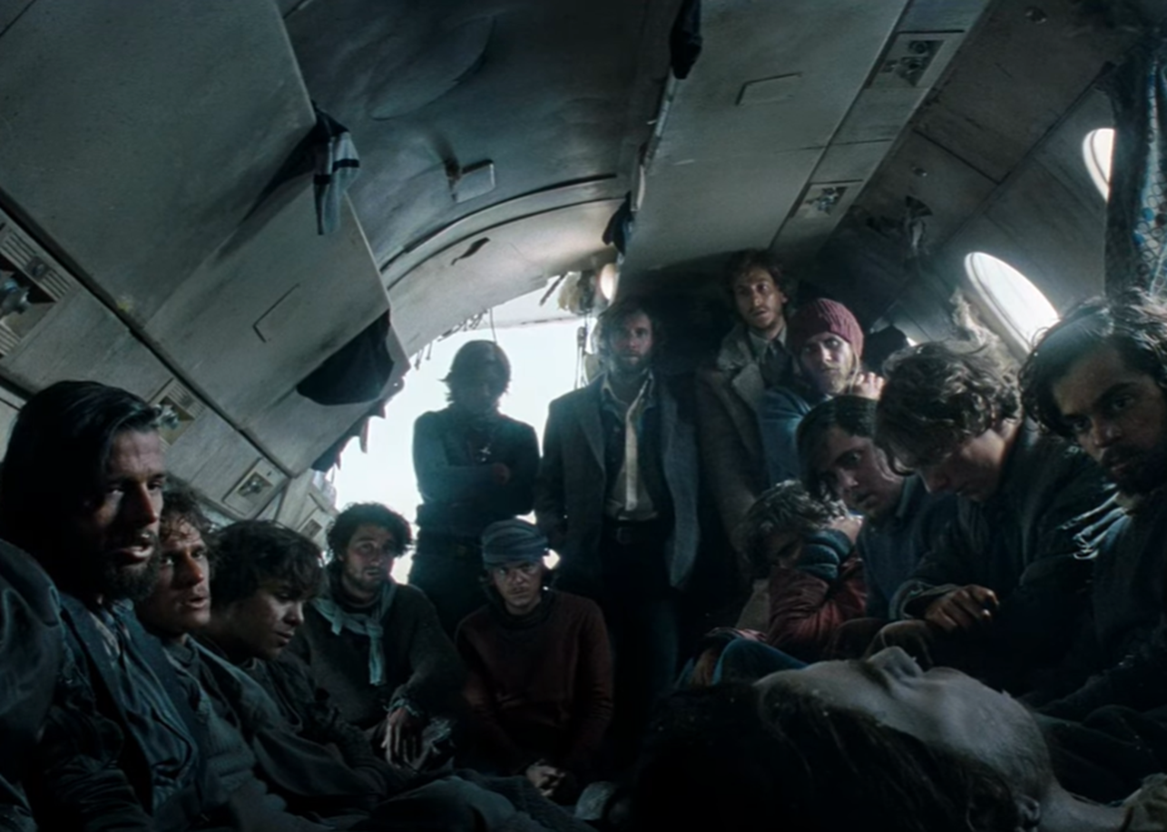 Screenshot of injured people looking scared in the plane body - from Society of the Snow (2023)
