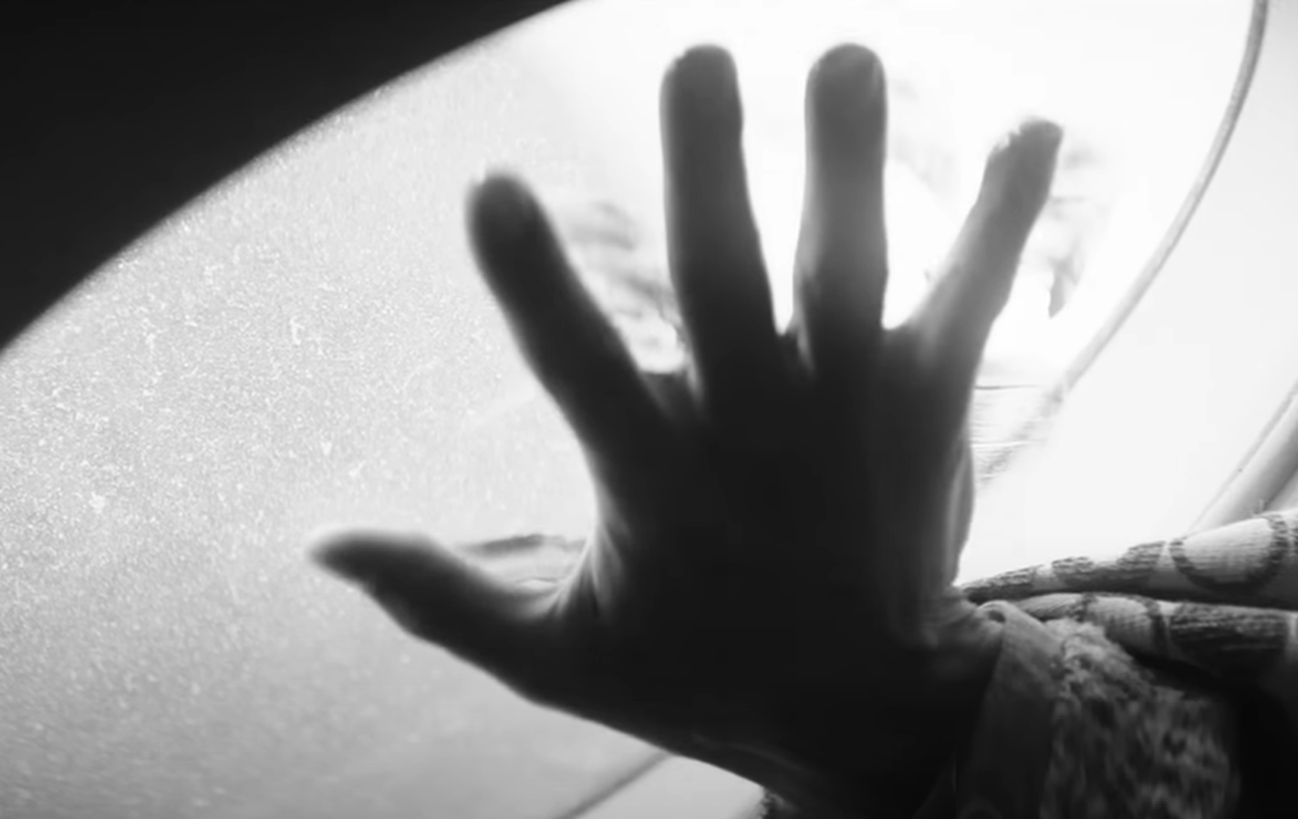 Screenshot of hand on the glass - from Society of the Snow (2023)