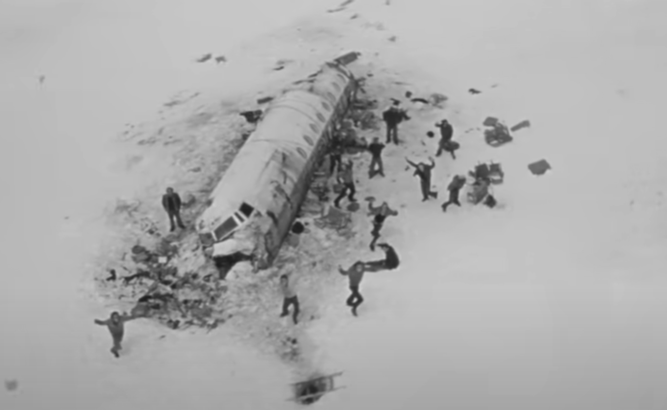 Screenshot of survivors from Flight 571 outside next to the plane parts - from Society of the Snow (2023)