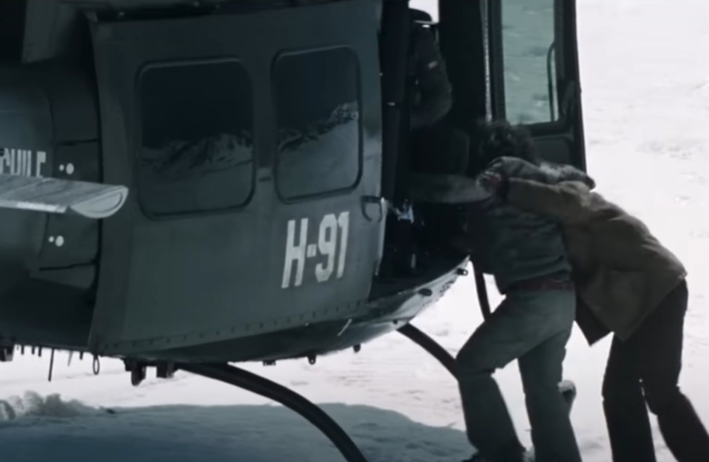 Screenshot of man getting in the army helicopter - from Society of the Snow (2023)
