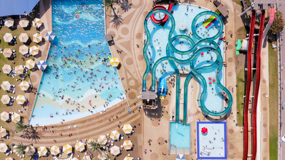 Top down aerial image of a large and crowded Water park with various slides and pools.