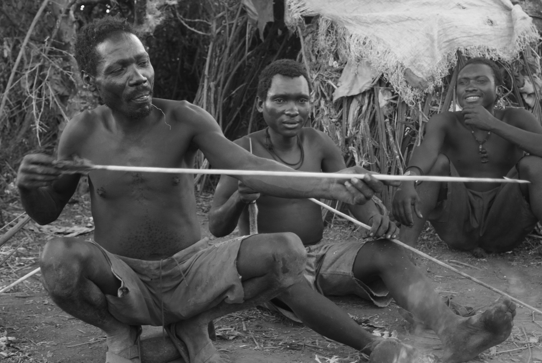 Unidentified member of the Hadza tribe works an arrow circa Feb 2012 in Lake Eyasi.