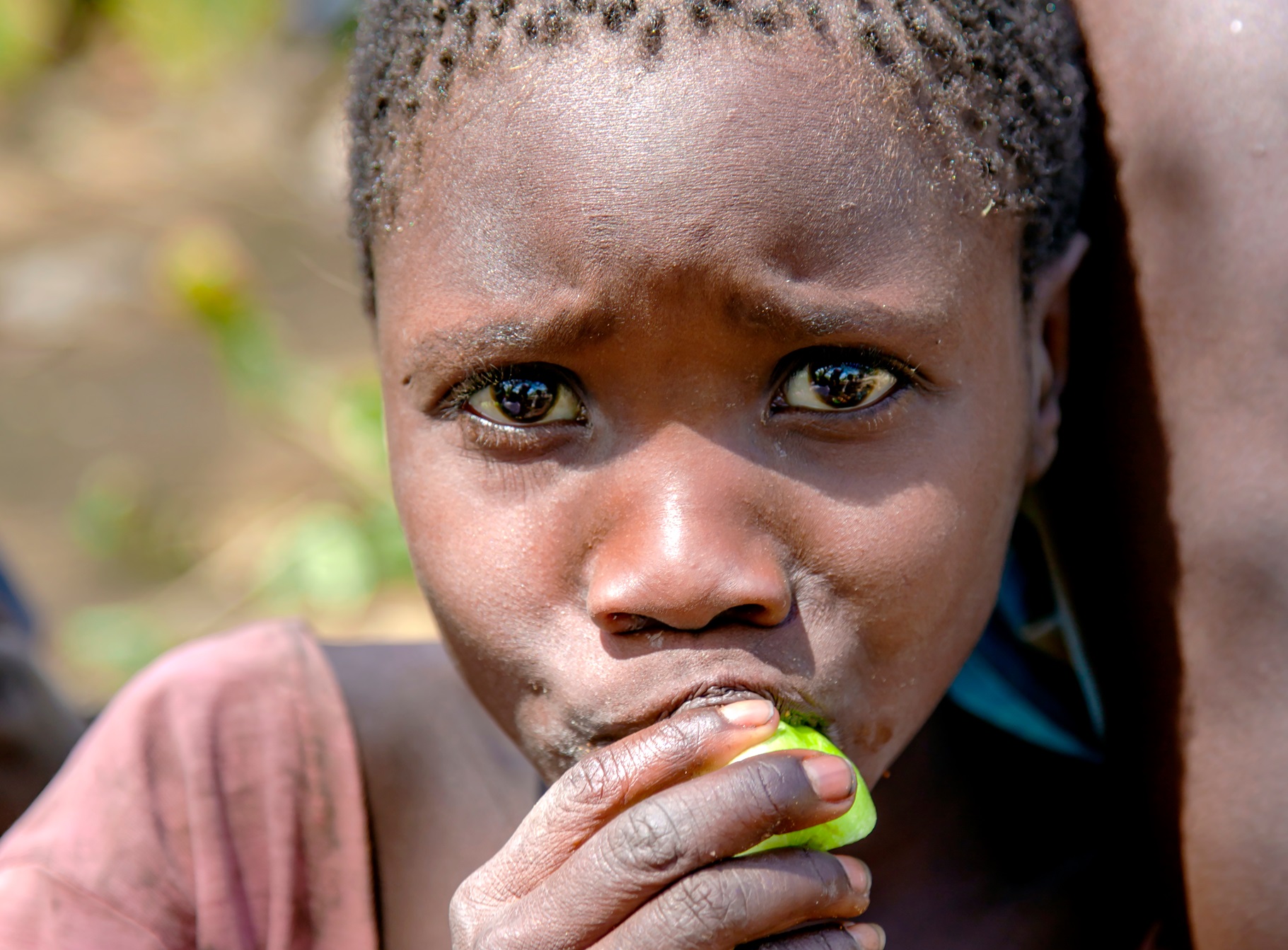 Portrait african girl of the Hadzabe tribe, that eats fruit in Tanzania, Africa - 2016