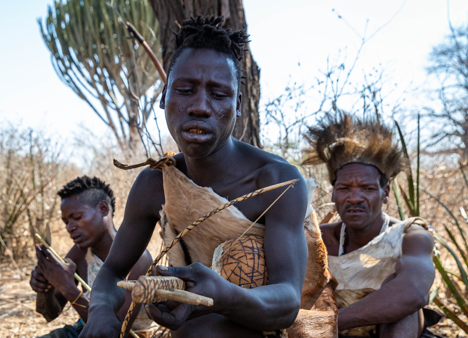 Hadzabe hunter signing a song using a local made ukelele.
