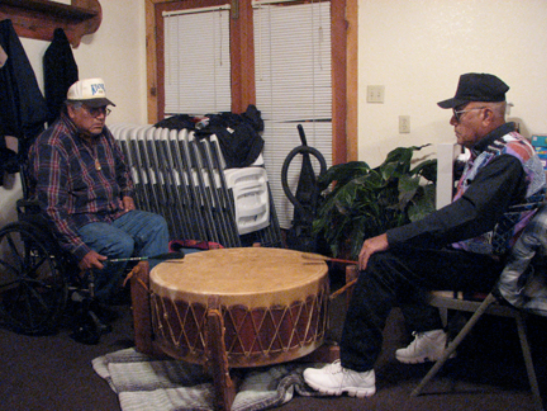 Comanche, drumming with friend