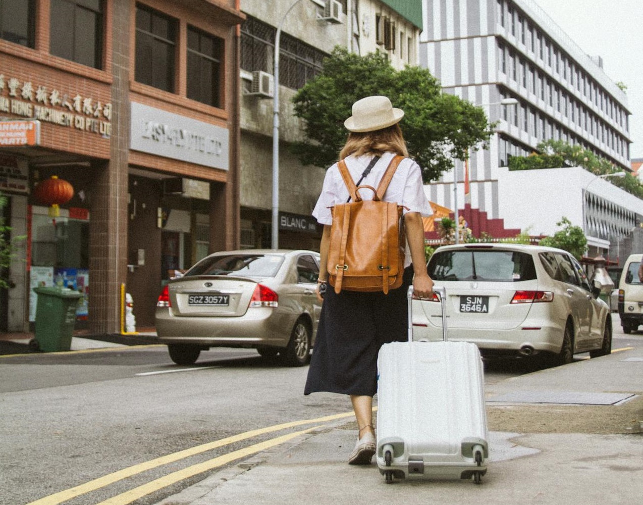 Senior woman with suitcase on the street.