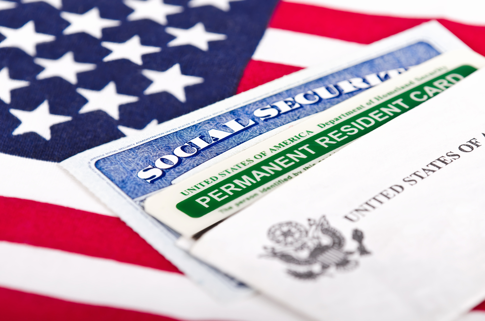 United States of America social security and green card with US flag on the background.