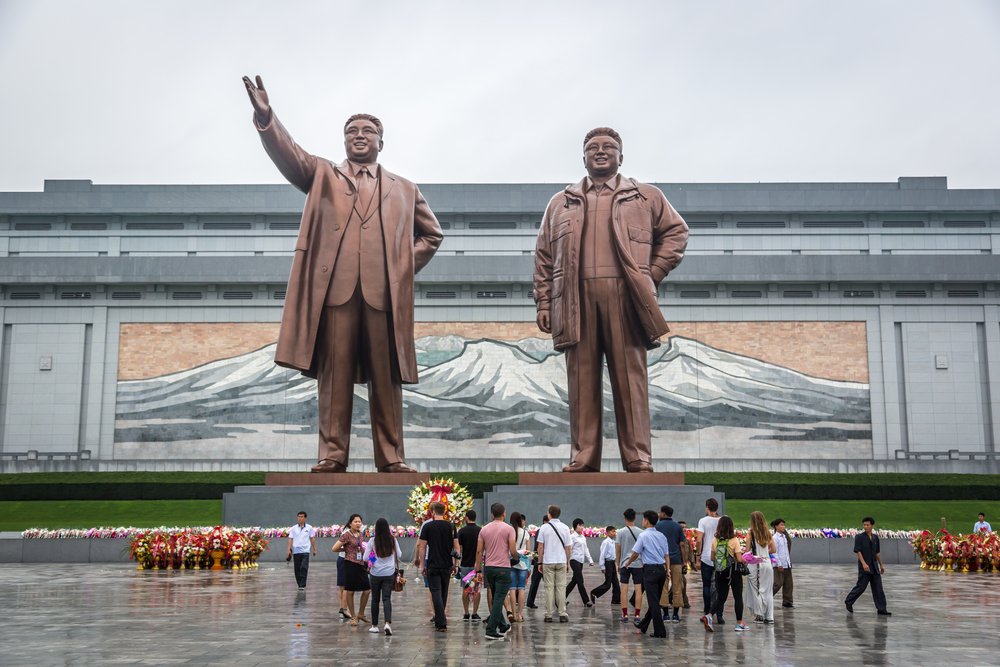 Locals and tourist in front of the Northern Korea leader statue in a cloudy day. Pyongyang - 2016