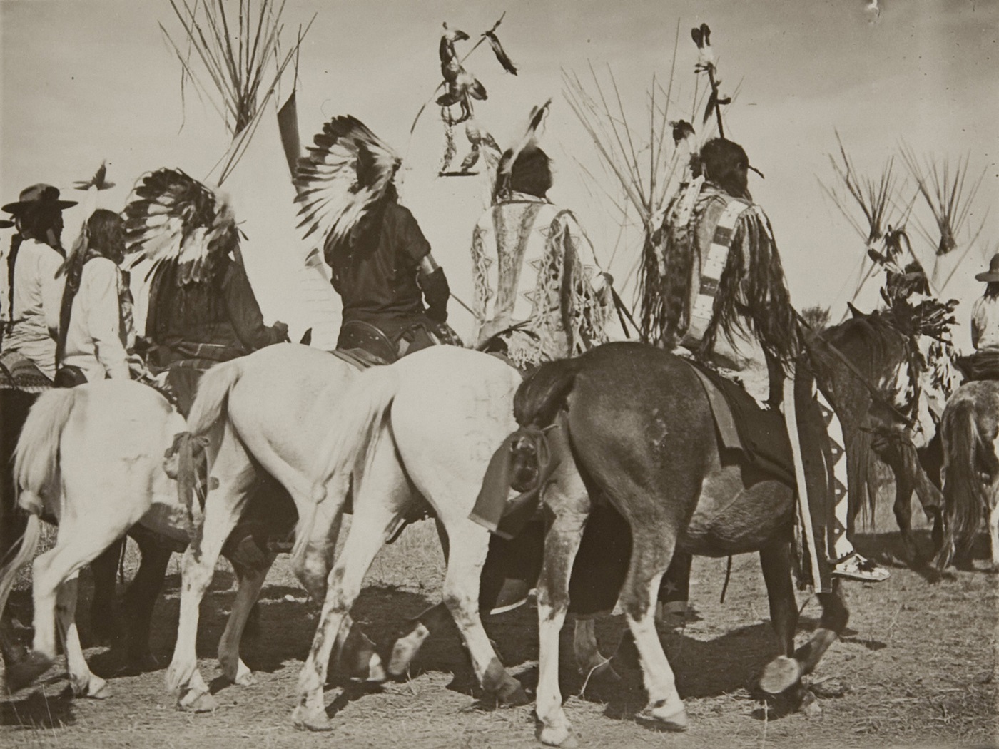 Rear view of Native Americans riding - 1910