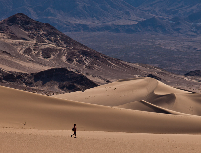 Person hiking in a sand dune field in Death Valley National Park