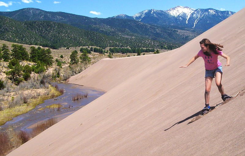 Girl Sandboarding Above Medano Creek, Castle Creek Picnic Area, Great Sand Dunes National Park & Preserve