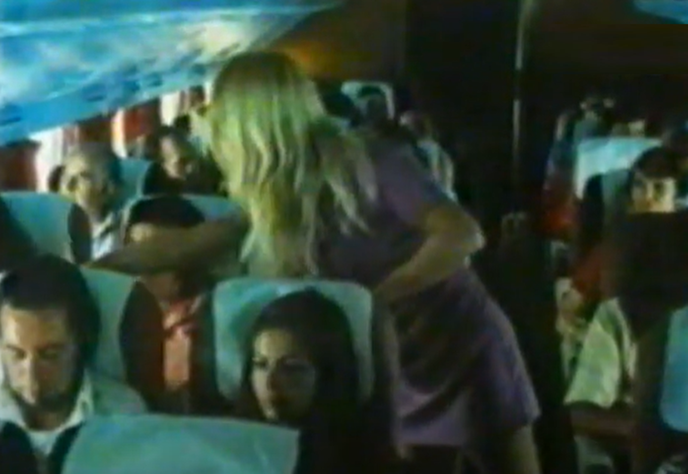 Screenshot of plane cabin with people - from Miracles Still Happen (1974)