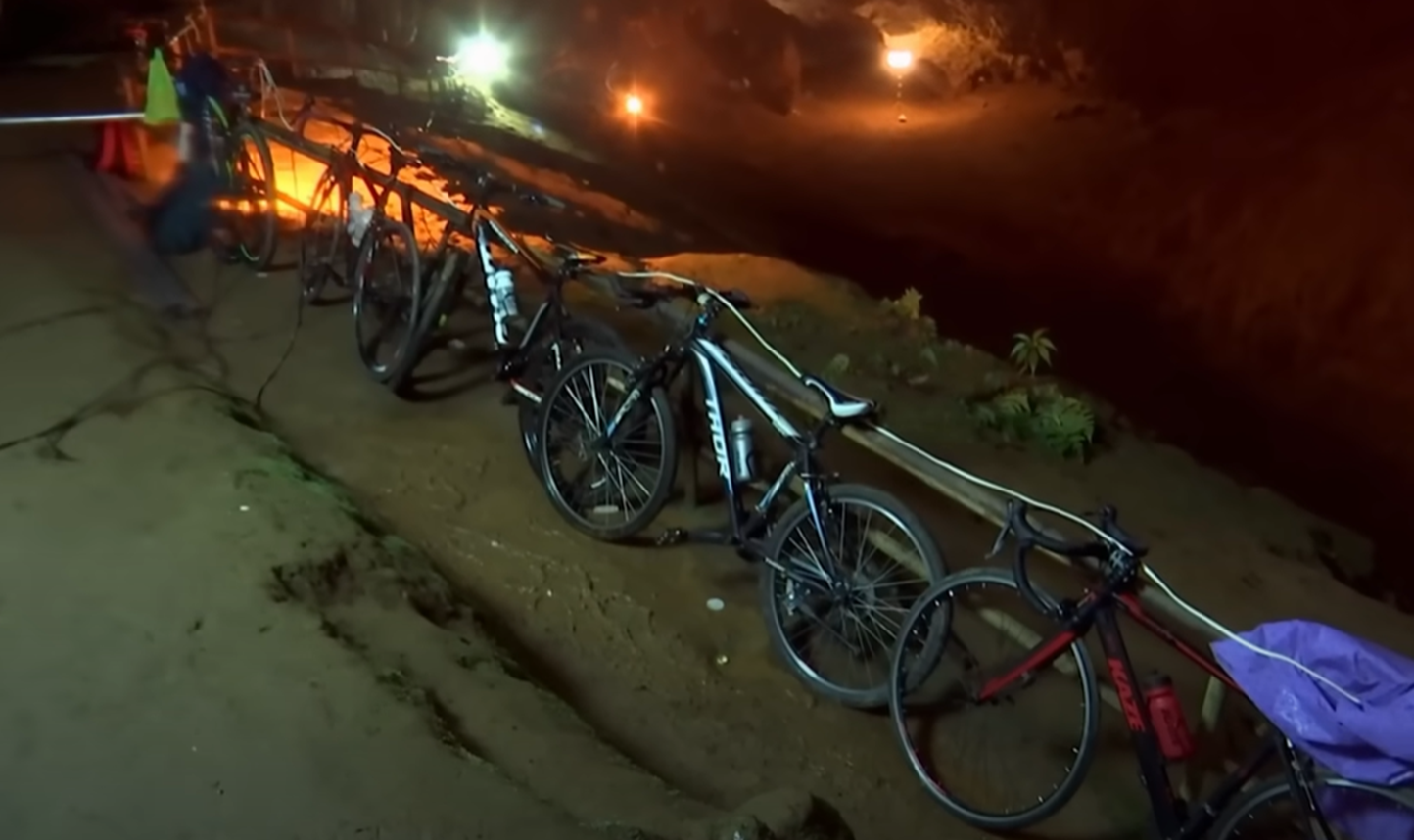 Screenshot of kids bikes at cave entrance - from Thai Cave Rescue (Drain the Oceans) 2019