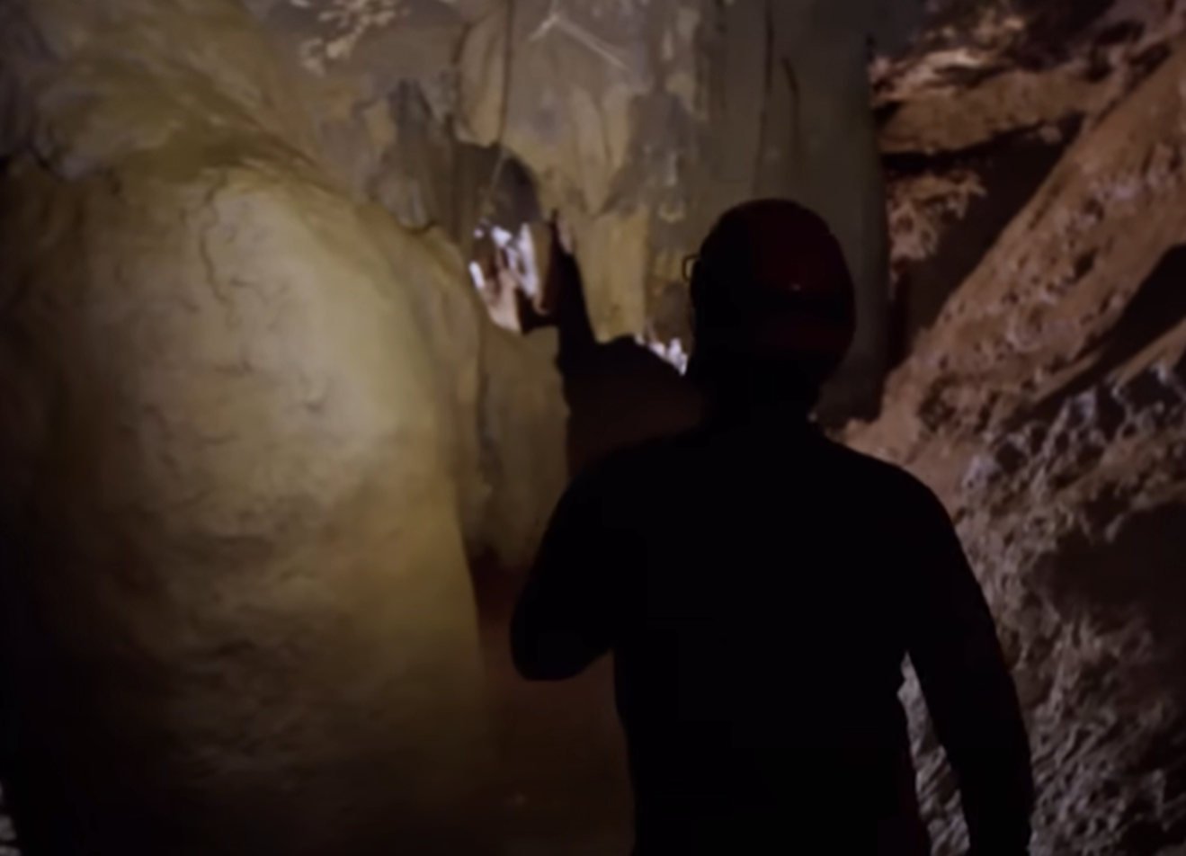 Screenshot of man in the cave - from Thai Cave Rescue (Drain the Oceans) 2019