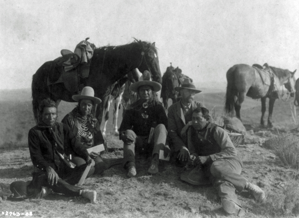 Photograph of Edward Curtis with three Indian Crow scouts and a Crow interpreter, visiting the Little Bighorn battlefield.