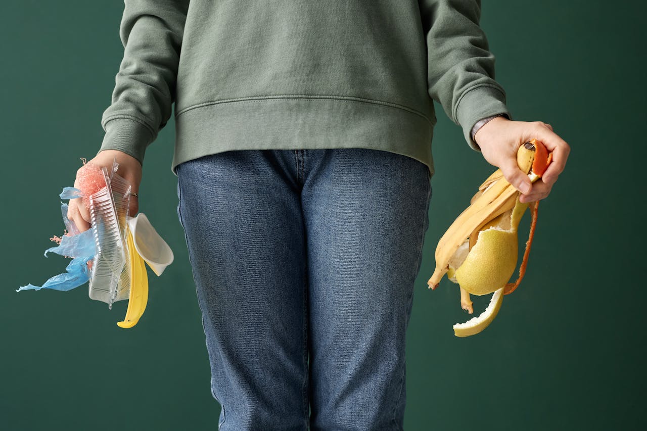 Person Holding Plastic and Organic Trash in Hands