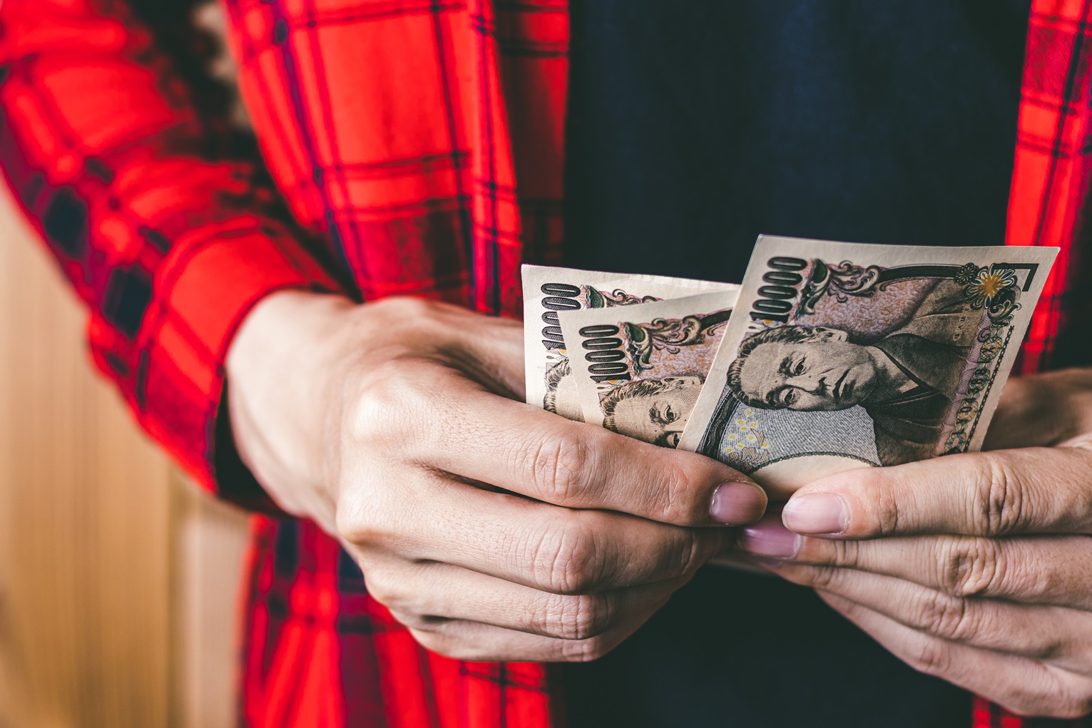 A man holding Japanese money